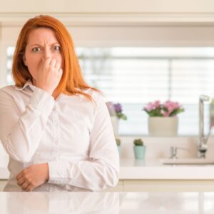 redheaded woman holding her nose