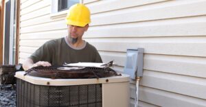 man working on rusty outdoor AC unit